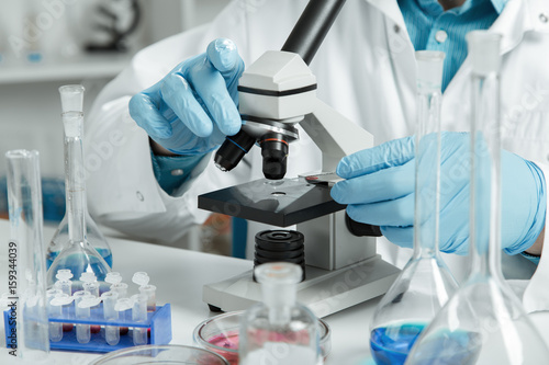 Tableau sur toile men in a laboratory microscope with microscope slide in hand