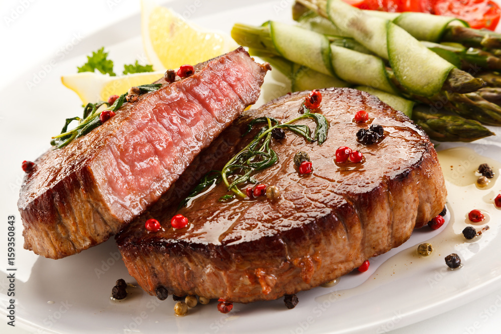 Grilled beefsteak with asparagus on white background Grilled beefsteak with asparagus on white background