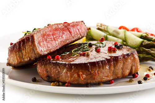 Grilled beefsteak with asparagus on white background 