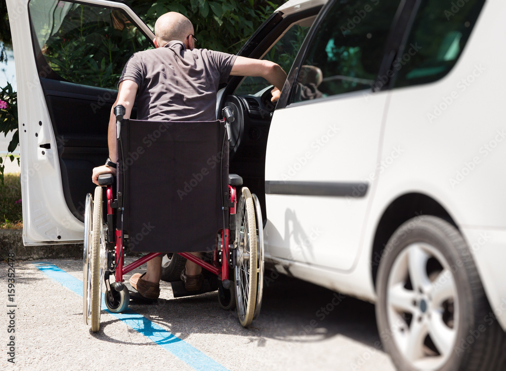 Adult Driver In Wheelchair Getting Into The Car