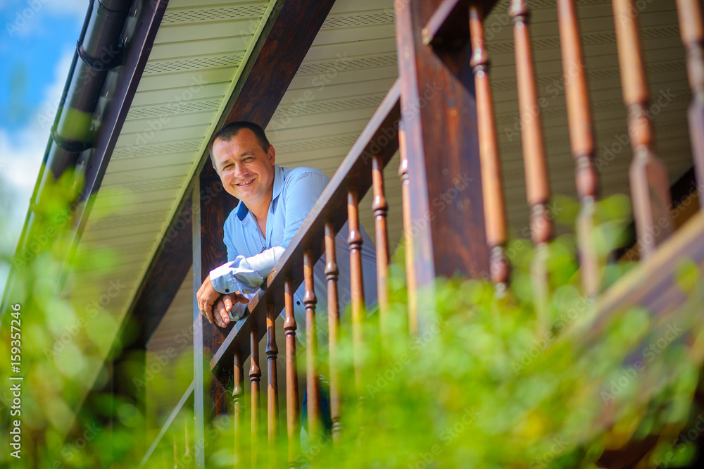 happy, confident man costs on a terrace of the house happy, confident man costs on a terrace of the house