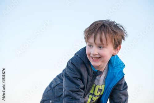 Handsome young boy outside smiling at sunset golden hour