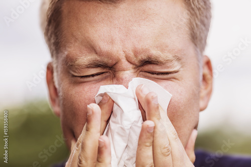Photos a young man snorts in a handkerchief