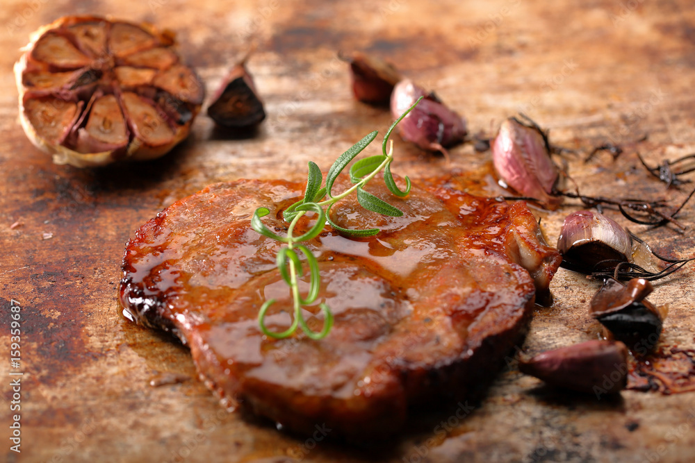 Fried grilled pork neck with garlic on rustic background