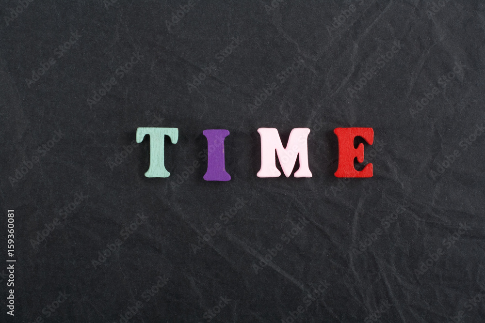 Time word on black board background composed from colorful abc alphabet block wooden letters, copy space for ad text. Learning english concept. Time word on black board background composed from colorful abc alphabet block wooden letters, copy space for ad text. Learning english concept.