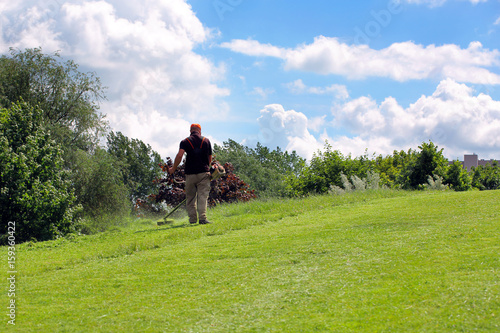 Man mow the grass on the hill © wideonet