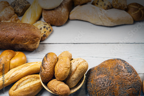 Assortment of baked bread on wooden rustic table background