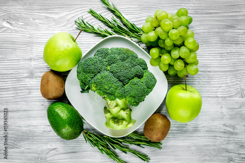 healthy food with green vegetables, fruits for dinner on gray table background top view photo