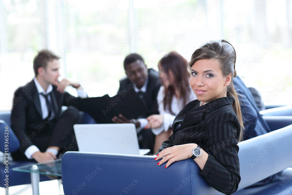 Young business woman standing with her co-wokers in background a Young business woman standing with her co-wokers in background a