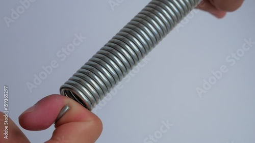 Man stretches the spring with his hands
