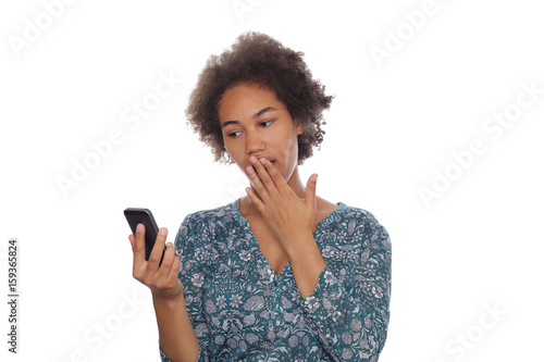 Junge Frau schaut erschrocken auf ihr Mobiltelefon