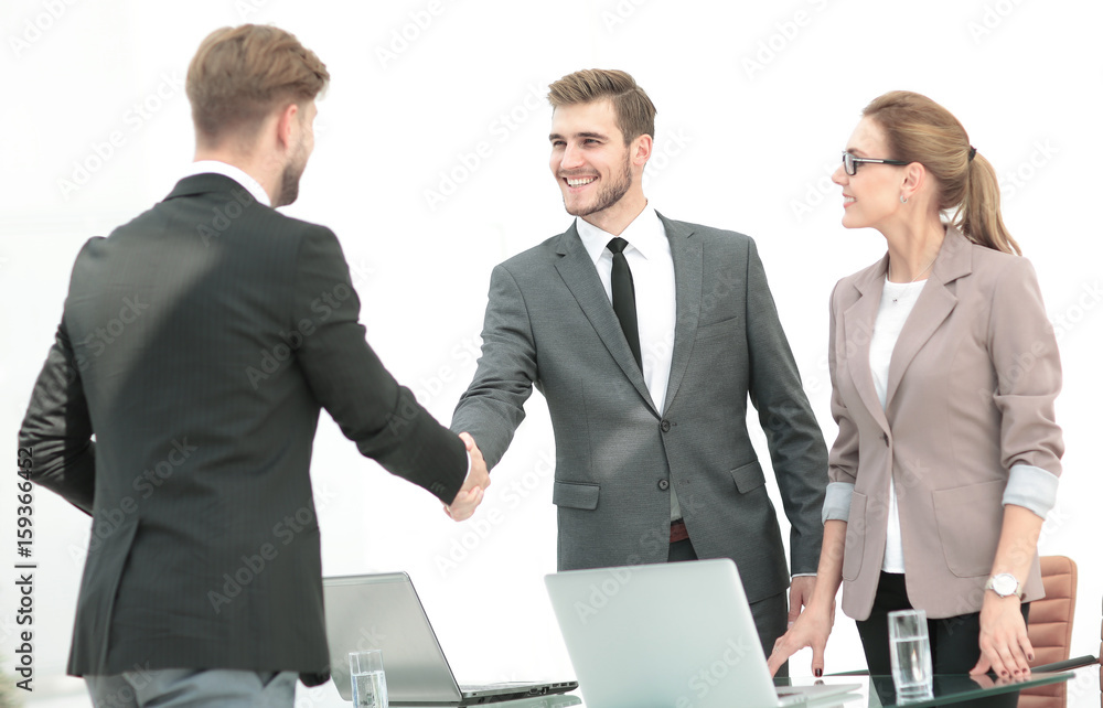 Fototapeta premium Happy smiling business people shaking hands after a deal in offi