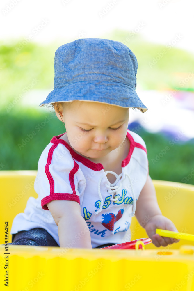 Fourteen months old baby girl playing with her colorful toys in the sand box Fourteen months old baby girl playing with her colorful toys in the sand box