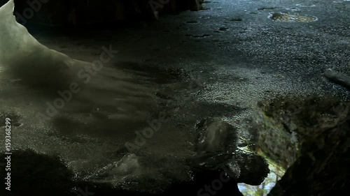 An icy stalagmite on the undeground lake in the big marble cave photo