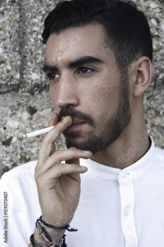 Fashion portrait of smoking young handsome man. photo