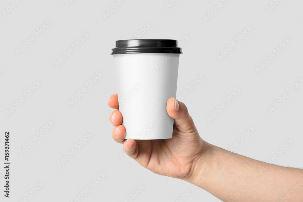 Mockup of male hand holding a Coffee paper cup isolated on light grey ...