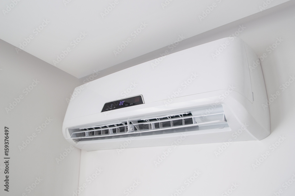 White split air conditioner on a white wall. Home interior in a small apartment White split air conditioner on a white wall. Home interior in a small apartment