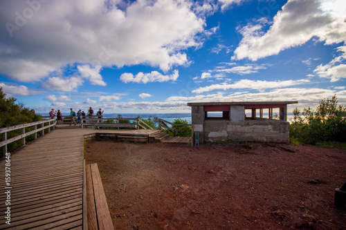 People enjoying the beautiful view from top in the mountain in Rangitoto Island wlaking in wooden paths  New Zealand in a sunny day