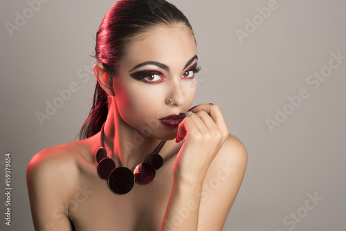 Foto beautiful girl with slicked back hair and make up with red eyes and lips with na