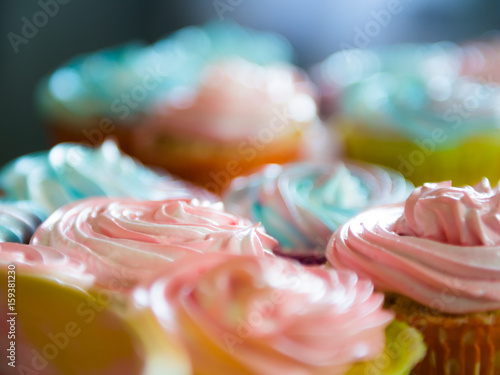 Multiple colorful nicely decorated muffins on a wooden background, top view The concept of homemade baking and hospitality at home