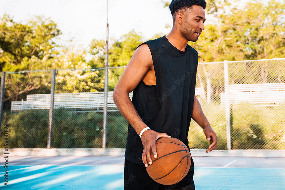 Basketball player holding ball.attractive,laugh,sport games,street  ball,black,sport outfit,casual wear,black clothes Stock Photo | Adobe Stock