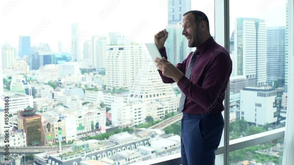 Happy businessman reading good news on tablet in office, super slow motion 240fps
Happy businessman reading good news on tablet in office, super slow motion 240fps