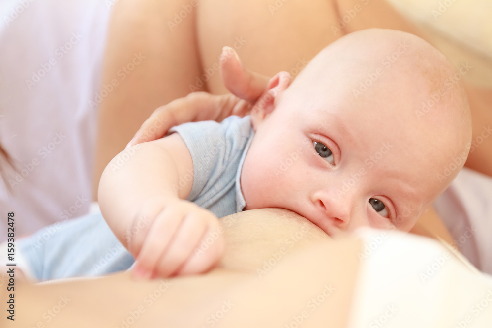 indoor portrait of mother breast feeding and hugging her baby, at home indoor portrait of mother breast feeding and hugging her baby, at home