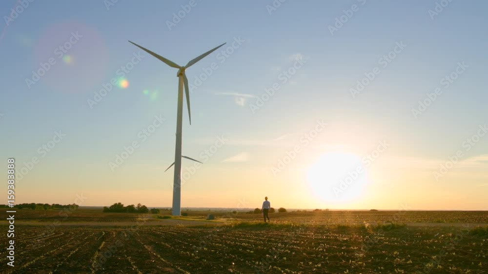 The engineer goes against the background of the windmills.