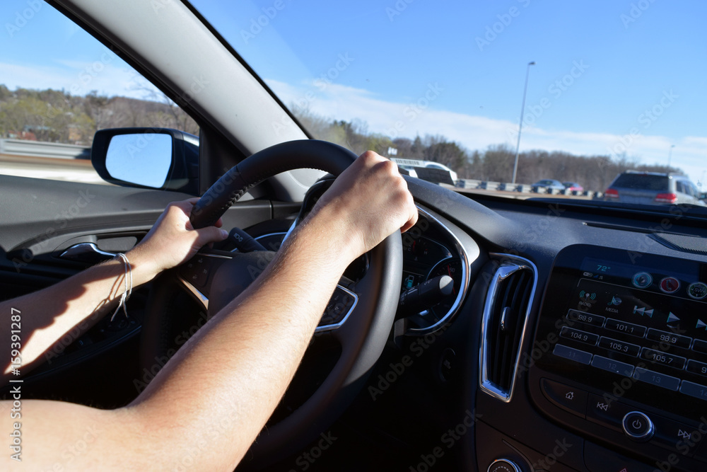 Male hands on the steering wheel