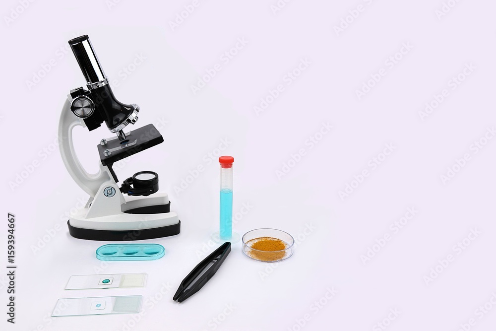 Microscope with slides and forceps and other lab equipment centered