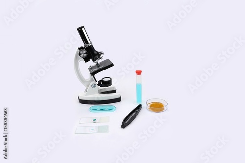 Microscope with slides and forceps and other lab equipment centered