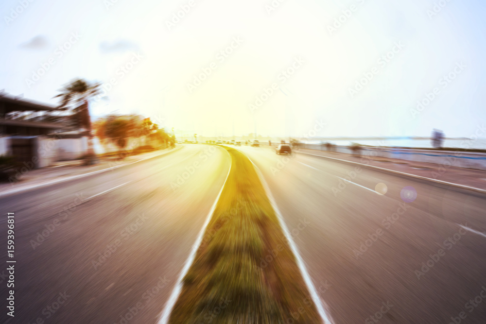 view of a road in motion blur effect and sun flares