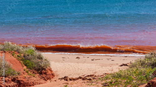 Red waves breaking on beach at high tide at James Price Point, Kimberley, Western Australia photo