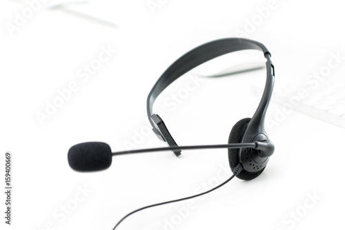 Microphone headset on white table with blur computer keyboard background