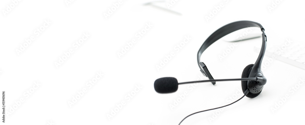 Microphone headset on white table with computer keyboard Microphone headset on white table with computer keyboard