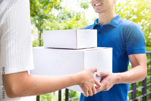 Courier deliver postal packages to a woman © Atstock Productions