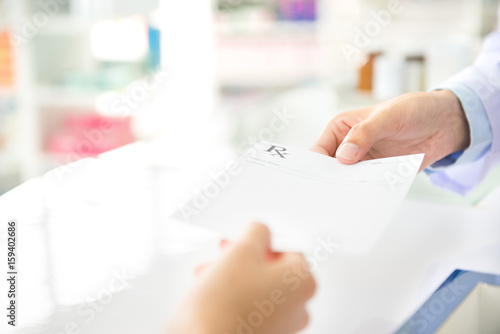 Customer giving prescription to pharmacist