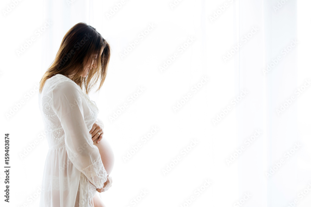 Portrait of young pregnant attractive woman, standing by the window, Portrait of young pregnant attractive woman, standing by the window,