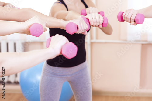 Sport Concepts and Ideas. Hands of Five Female Athletes Standing Together in Circle with Barbells