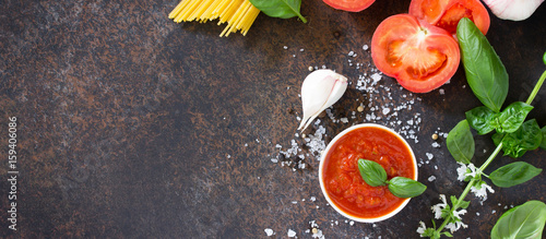 Culinary background for cooking pasta, tomato sauce, fresh herbs and spices. Copy space.