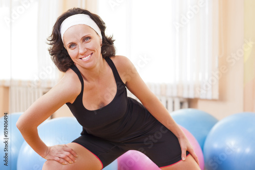 Sport, Fitness, Wellness and Lifestyle Ideas.Portrait of Female Caucasian Athlete In Good Fit Posing Against Fitballs in Gym.