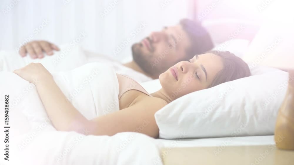 The lovely woman sleeping near the man on the bed The lovely woman sleeping near the man on the bed