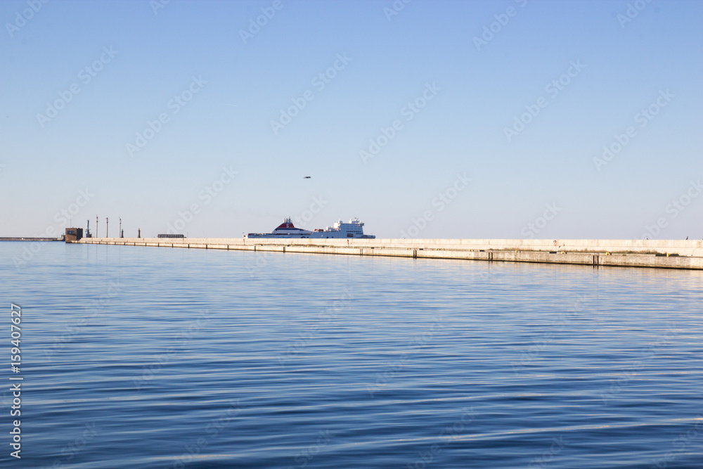Concrete breakwater and white cruise liner