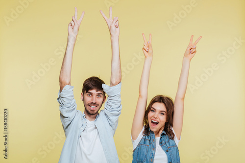 Happy brother and sister showing peace gesture