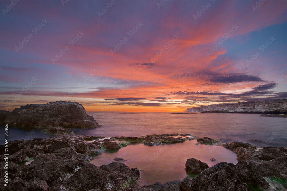 sea sunset on the rocks and flaming sky