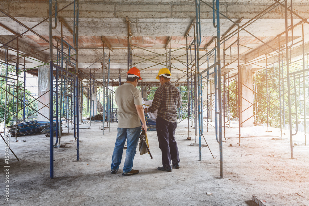 Engineer discussing with foreman about project in building construction site Engineer discussing with foreman about project in building construction site