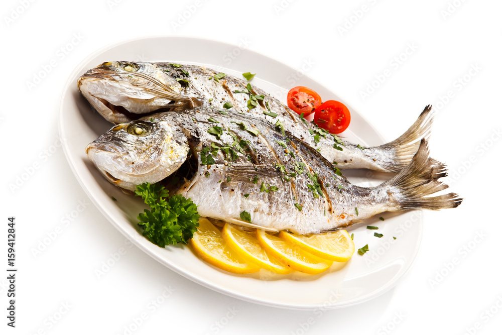 Fish dish - roast fish and vegetables on white background Fish dish - roast fish and vegetables on white background