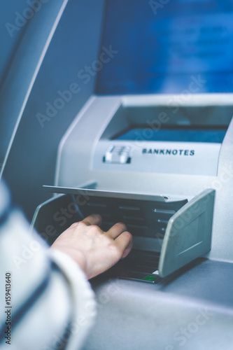 Woman using cash machine-ATM,close up view.