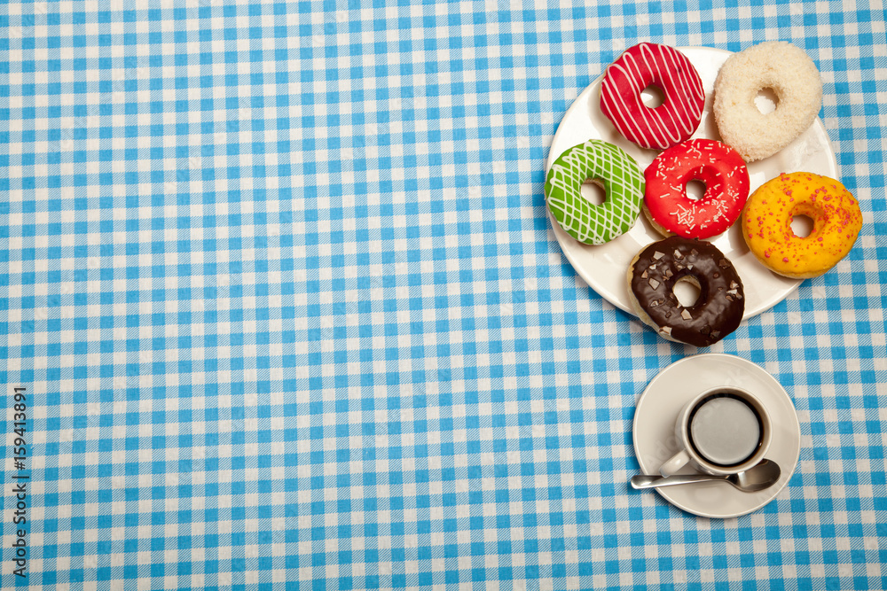 Cup with coffee and donuts on a blue table