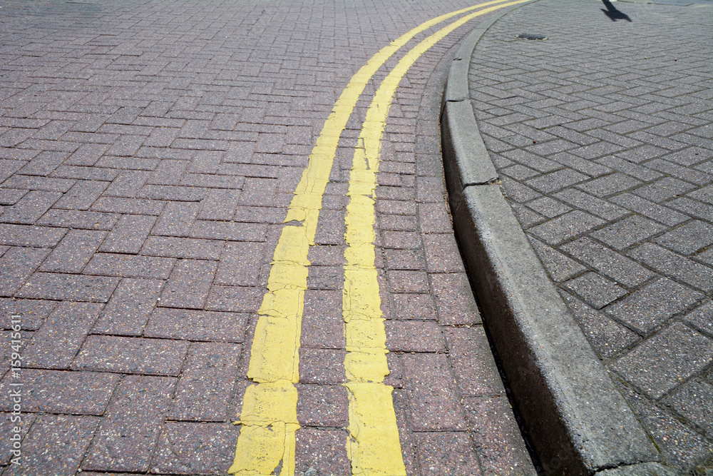 Double yellow line painted on road with hard-wearing brick surface